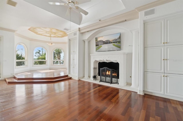 unfurnished living room with visible vents, a tray ceiling, dark wood-style flooring, and a high end fireplace