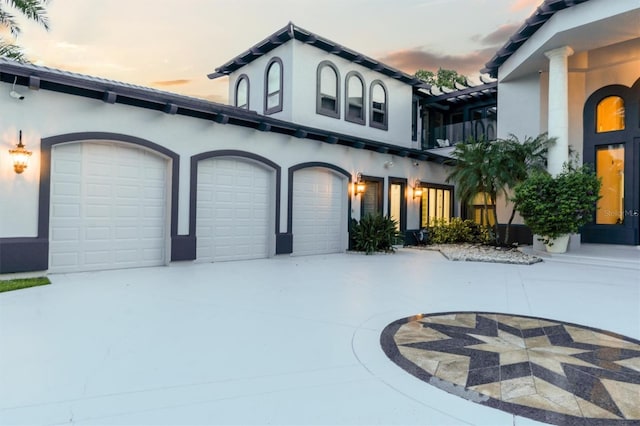 view of front of house featuring a garage, concrete driveway, and stucco siding