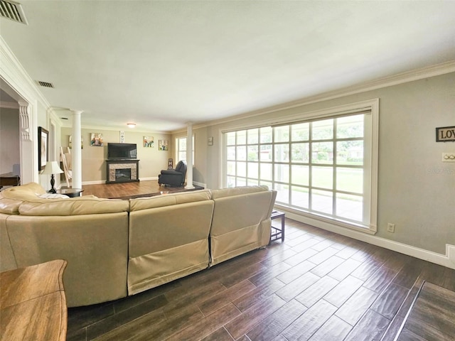 living room with crown molding and ornate columns