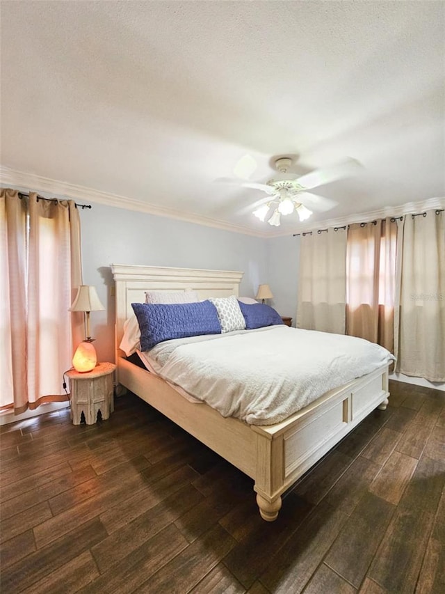 bedroom featuring ceiling fan, dark hardwood / wood-style floors, and ornamental molding