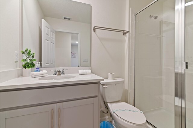 bathroom with vanity, toilet, and an enclosed shower