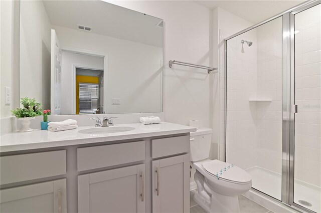 bathroom featuring walk in shower, tile patterned floors, toilet, and vanity