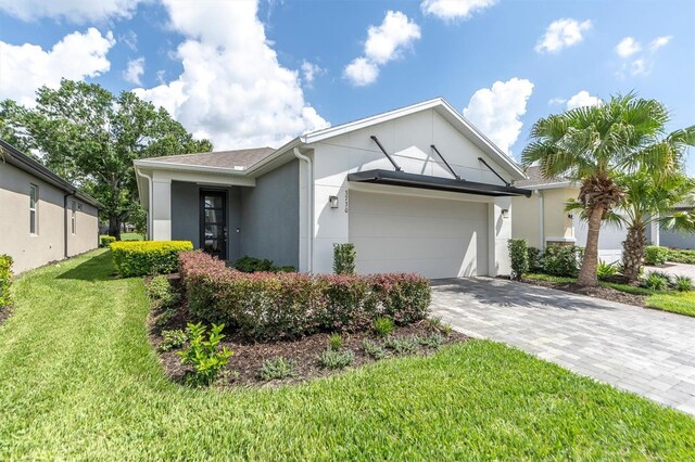 view of front of property with a garage, a front yard, and solar panels