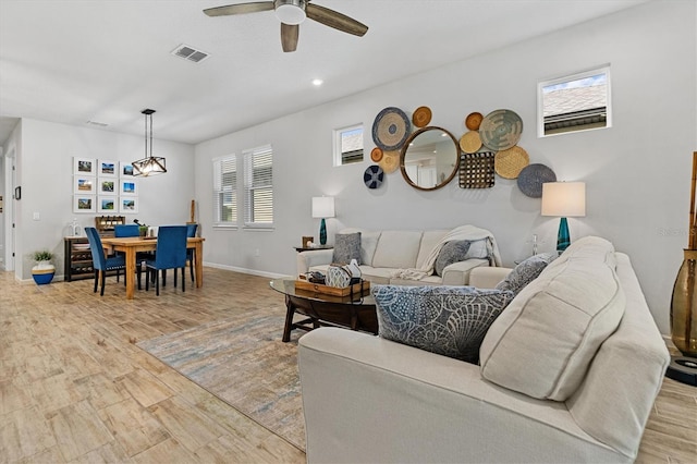 living room with light wood-type flooring and ceiling fan