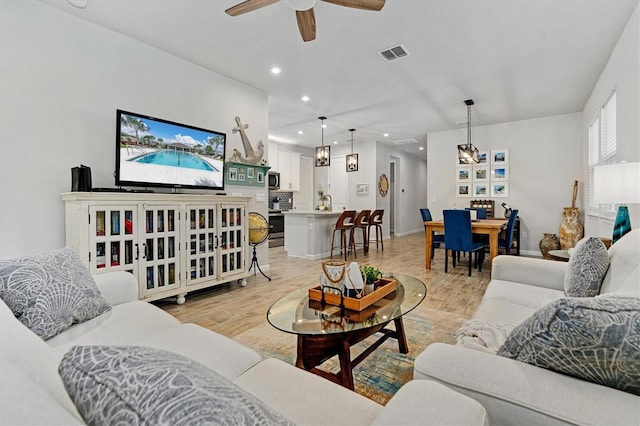 living room with ceiling fan and light hardwood / wood-style floors