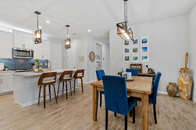 dining room with sink and light wood-type flooring