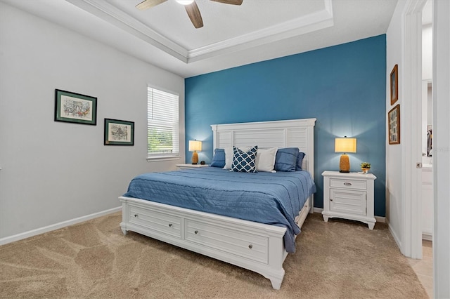 bedroom with ceiling fan, light carpet, a tray ceiling, and ornamental molding