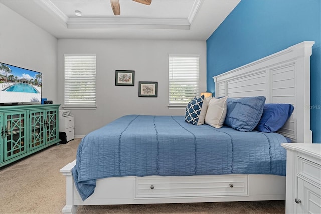 bedroom featuring light carpet, ceiling fan, and a raised ceiling