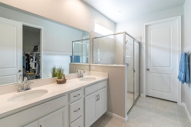 bathroom with tile patterned flooring, walk in shower, and vanity