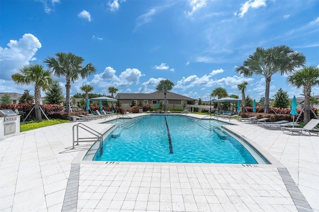 view of swimming pool featuring area for grilling and a patio