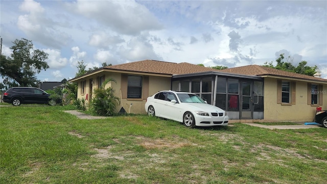 view of front of property with a sunroom and a front lawn