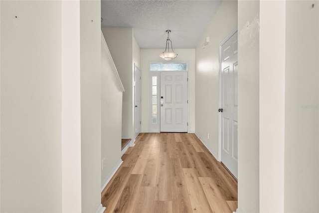 foyer featuring a textured ceiling and light hardwood / wood-style flooring