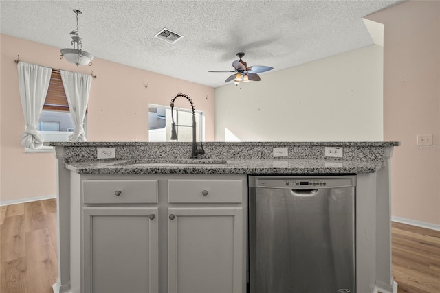 kitchen featuring ceiling fan, a textured ceiling, stainless steel dishwasher, light hardwood / wood-style flooring, and sink