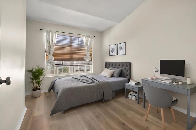 bedroom with lofted ceiling and light hardwood / wood-style flooring