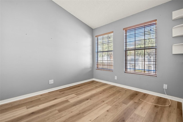 unfurnished room featuring light hardwood / wood-style flooring and vaulted ceiling