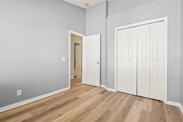 unfurnished bedroom featuring light wood-type flooring and a closet