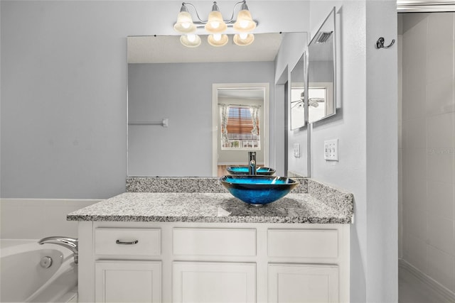 bathroom with a washtub, vanity, and an inviting chandelier