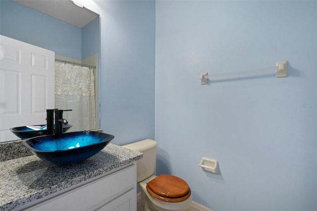 bathroom featuring toilet, a shower with curtain, and vanity