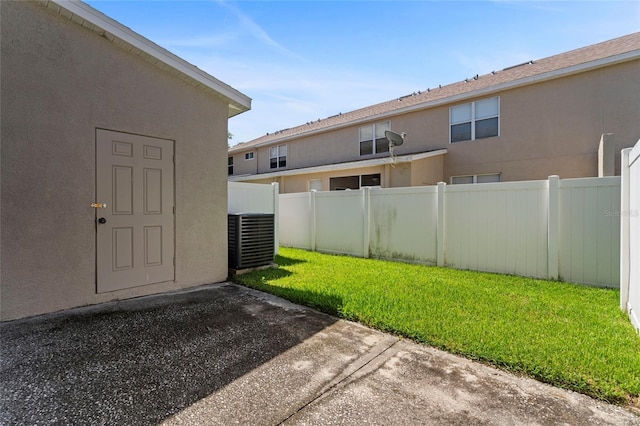 view of yard with central AC and a patio