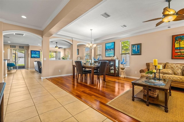 dining room featuring ceiling fan with notable chandelier, light hardwood / wood-style floors, and ornamental molding