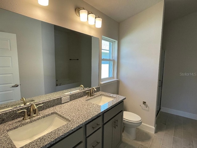 bathroom featuring vanity, toilet, and a textured ceiling