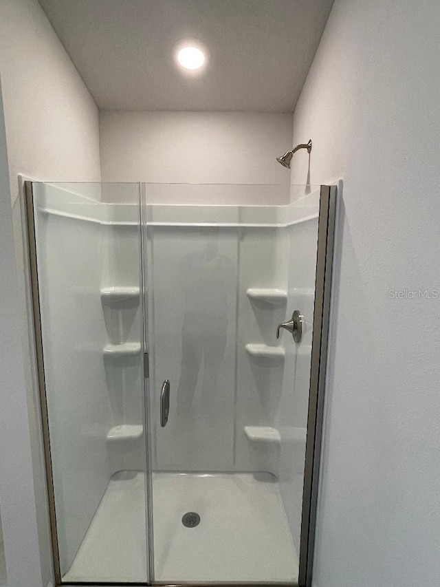 bathroom with a shower with door