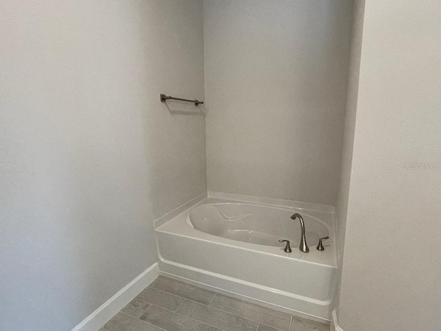 bathroom with tile patterned floors and a bath