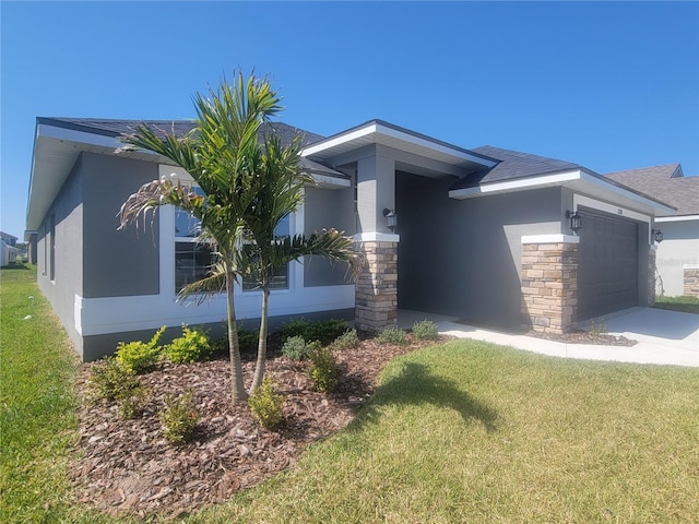 view of front facade with a front yard, concrete driveway, a garage, and stucco siding