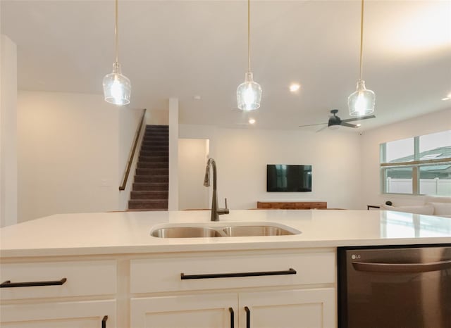 kitchen featuring pendant lighting, sink, white cabinetry, and stainless steel dishwasher