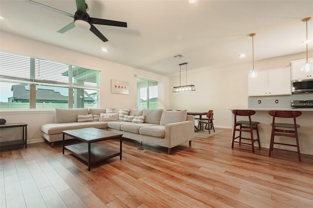 living room featuring ceiling fan and light hardwood / wood-style flooring