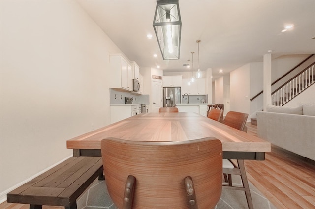 dining space with light wood-type flooring and sink