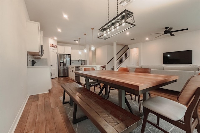 dining room featuring ceiling fan, hardwood / wood-style flooring, and sink