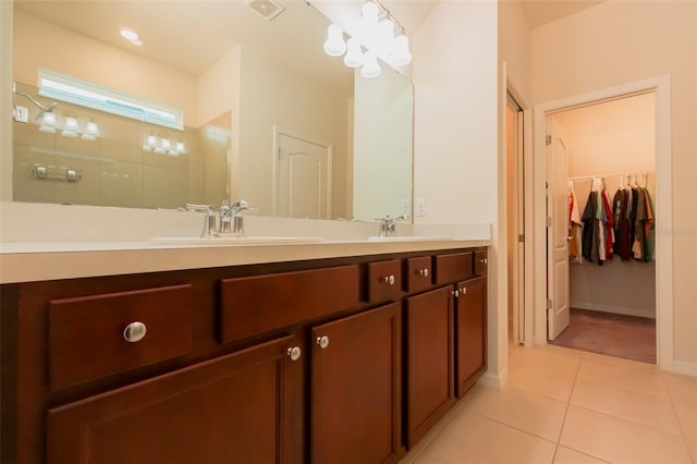 bathroom featuring vanity, tile patterned flooring, and a shower