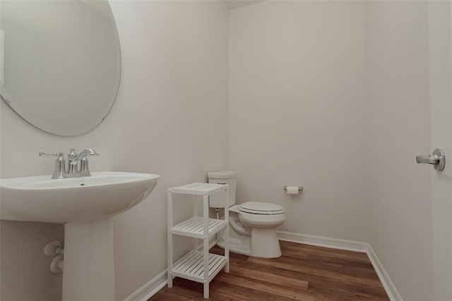 bathroom featuring toilet, wood-type flooring, and sink