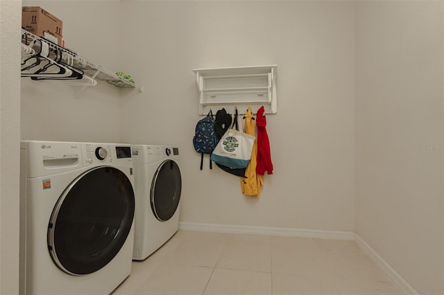 laundry room featuring washer and dryer and light tile patterned flooring