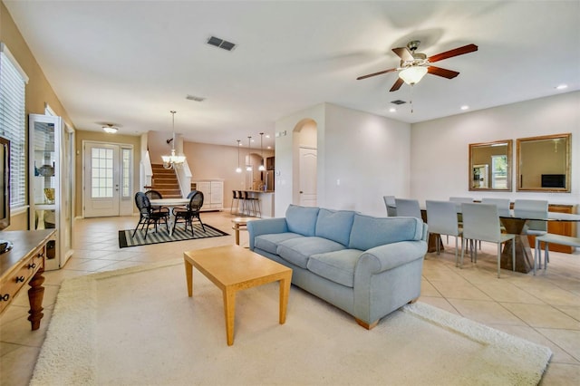 living room with light tile patterned floors and ceiling fan with notable chandelier