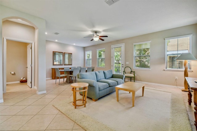 tiled living room with ceiling fan and a wealth of natural light