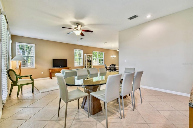 dining space featuring ceiling fan with notable chandelier and light tile patterned floors