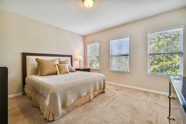 carpeted bedroom featuring multiple windows