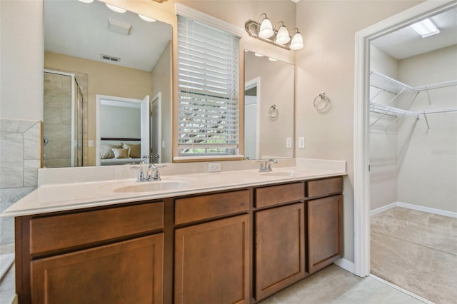 bathroom featuring tile patterned flooring, a shower with door, and vanity