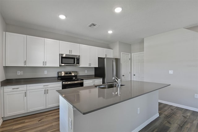 kitchen featuring white cabinetry, stainless steel appliances, dark hardwood / wood-style flooring, sink, and a kitchen island with sink