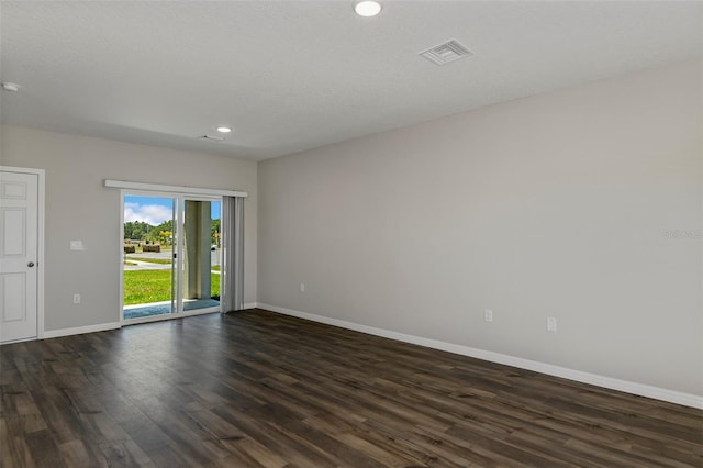 empty room with a textured ceiling and dark hardwood / wood-style flooring