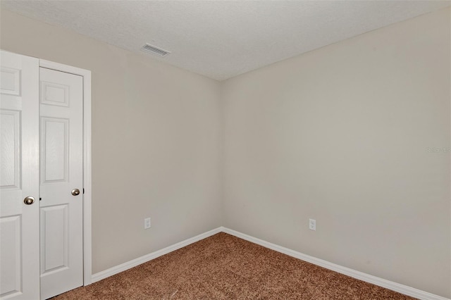 spare room with carpet floors and a textured ceiling