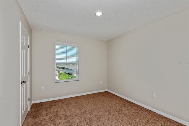 carpeted spare room featuring a textured ceiling