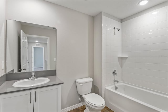 full bathroom featuring tiled shower / bath, wood-type flooring, vanity, and toilet