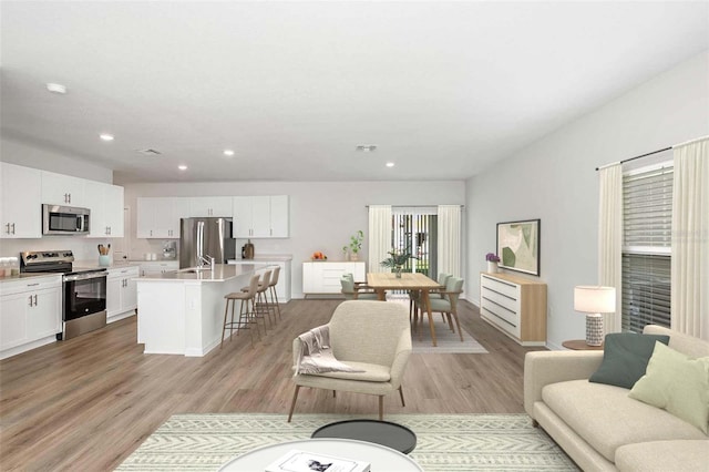 living room featuring light wood-type flooring and sink