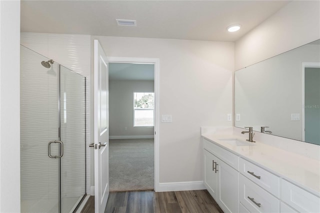 bathroom featuring a shower with door, wood-type flooring, and vanity