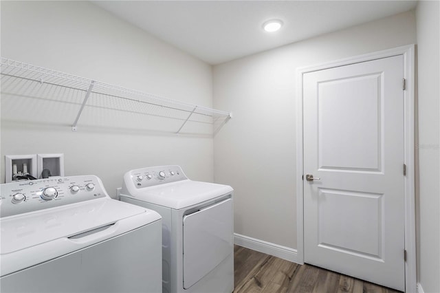 clothes washing area with dark hardwood / wood-style flooring and independent washer and dryer