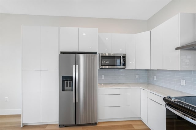 kitchen with tasteful backsplash, stainless steel appliances, light wood-type flooring, and white cabinets