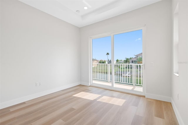 unfurnished room featuring a water view, a healthy amount of sunlight, and light wood-type flooring